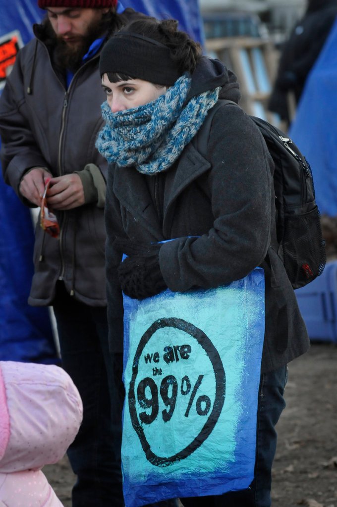 Erika Jordan of Auburn is bundled against the cold at an Occupy Maine meeting in Portland on Sunday. The group decided to file suit against the city to try to stay in Lincoln Park.