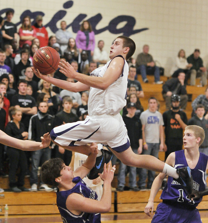 Jon Amabile, who scored 15 of his game-high 20 points for Deering in the first half Tuesday night, soars over Troy Pappas of Marshwood for a layup. Deering, down 30-25 at halftime, earned a 67-64 victory.