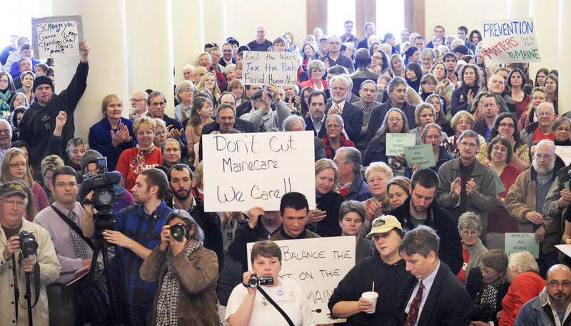 Defenders and opponents of Medicaid cuts fill the State House Hall of Flags on Wednesday in Augusta, where two legislative committees heard testimony on Gov. Paul LePage’s proposal to cover a $221 million deficit. The testimony continues today and Friday.