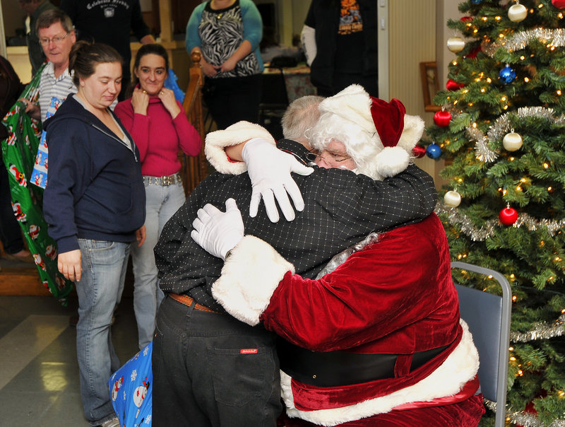 Another Port Resources client, Robert of Limington, hugs Santa Claus, who arrived at the holiday celebration with a big bag of presents.