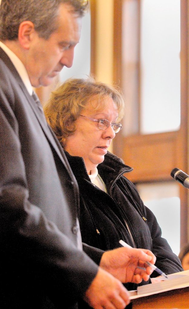 Bettysue Higgins stands Wednesday with her attorney Ronald Bourget in Kennebec County Superior Court where she pleaded guilty to embezzling $166,000 from the Maine Trial Lawyers Association.