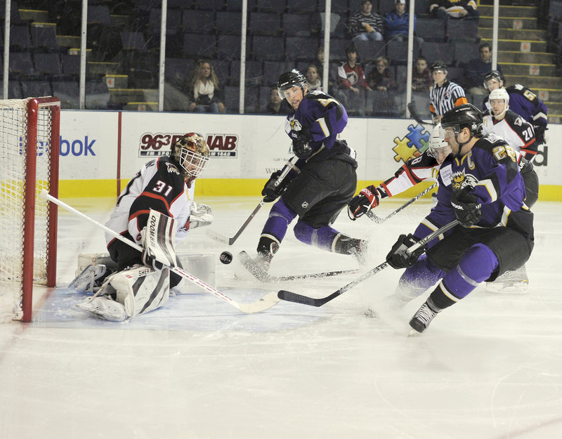 Curtis McElhinney, the goalie for the Portland Pirates, turns away a shot by Marc-Andre Cliche of the Manchester Monarchs, right, in the first period of the Monarchs’ 2-1 victory Wednesday night at the Cumberland County Civic Center. Cliche is a former Lewiston Maineiac.