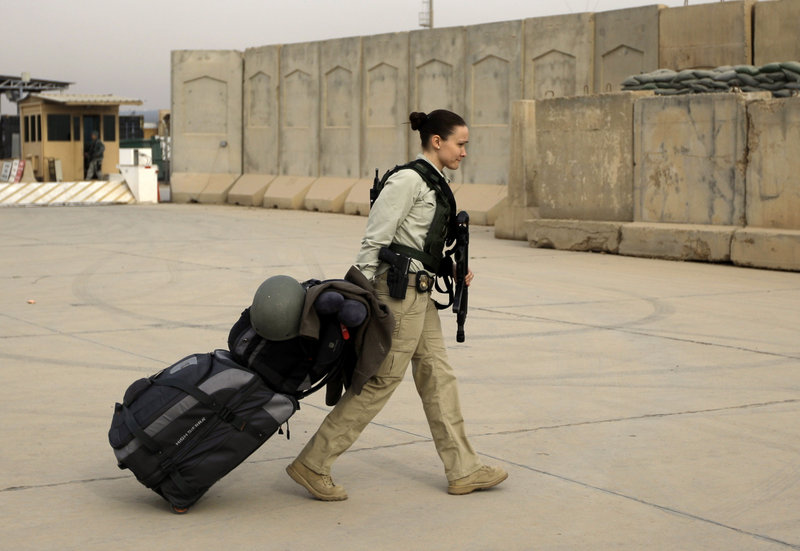 A security contractor begins her journey home after ceremonies Thursday marking the end of U.S. military mission in Iraq.