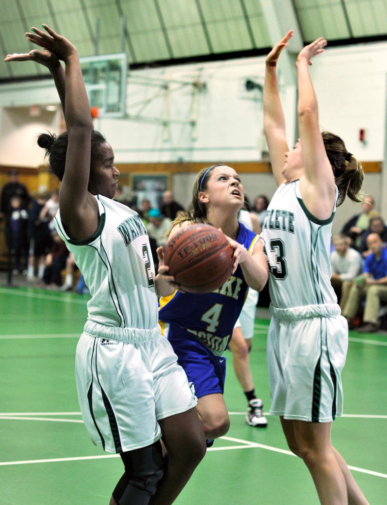 Sydney Hancock of Lake Region splits the defense, looking for room between Rhiannan Jackson, left, and Leigh Fernandez of Waynflete during their Western Maine Conference game Thursday. Lake Region won, 45-36.