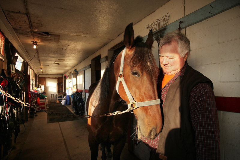 Ernie Lowell talks to Best Edition on Friday in a stable at Scarborough Downs, where he has been shoeing horses for 43 years. Lowell has been worried about the future of the track and the harness racing industry in general since a proposed racino in Biddeford was defeated last month.