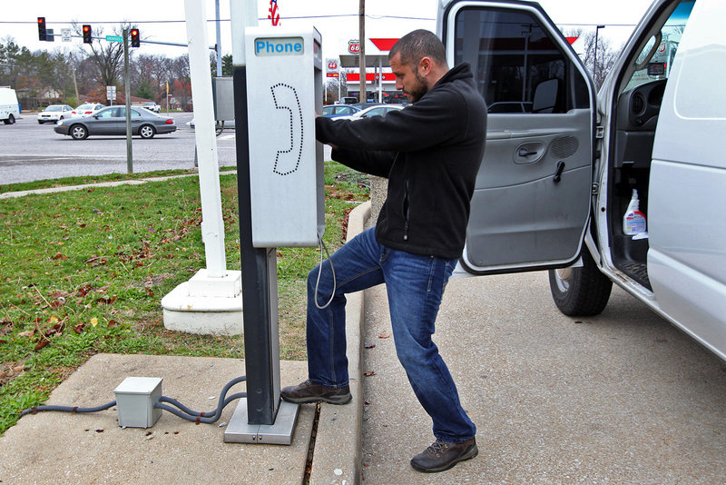 Joe Nesselhauf checks the operation on a pay phone in Mehlville, Mo., that is part of the business started by his grandfather. With the proliferation of cellphones, the pay phone business is dying out.