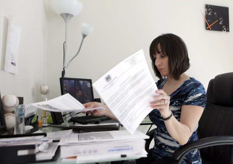 Gina Marie Haynes looks over documents before a job interview in Frisco, Texas. She has spent hours calling background check companies to get her record corrected after an outdated fraud charge, arising from a dispute over a car purchase, cost her a job.