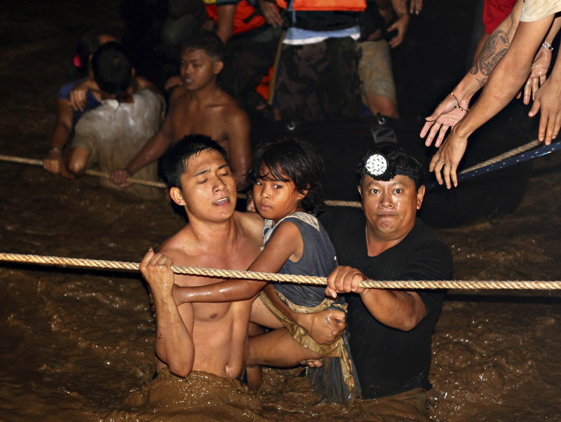 Residents are rescued by volunteers following a flash flood that inundated Cagayan de Oro city, Philippines, on Saturday.