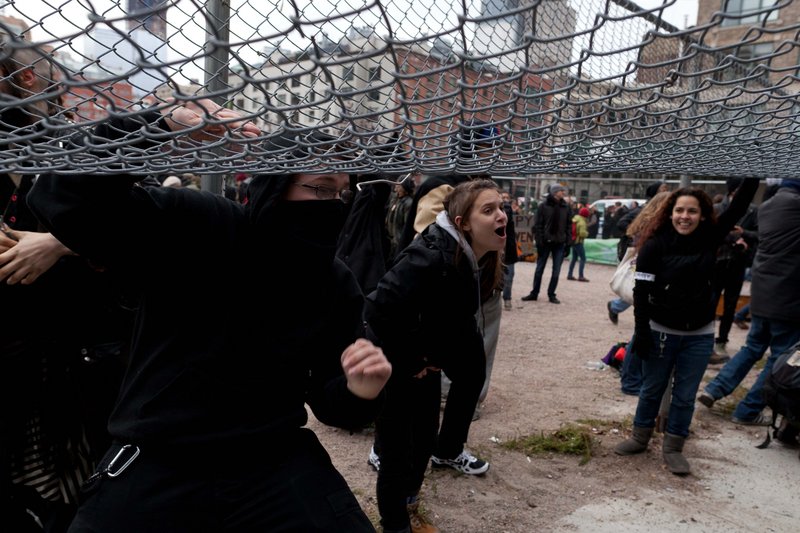 Occupy Wall Street protesters lift a fence as they attempt to move onto land owned by the Episcopal Church in New York. A church official said that the lot would not be conducive to hosting the protesters.