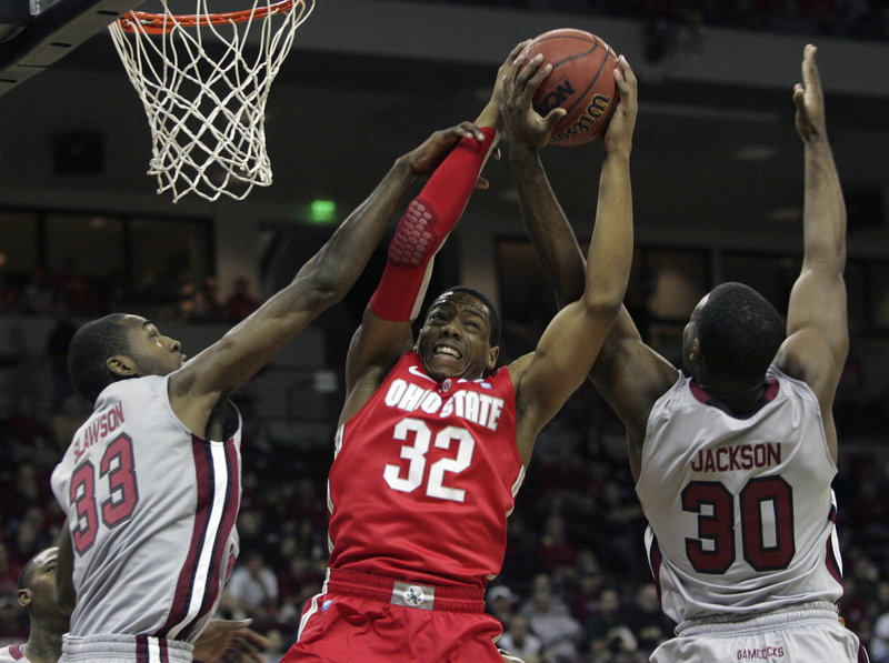 Lenzelle Smith of Ohio State grabs a rebound between South Carolina’s R.J. Slawson, left, and Lakeem Jackson during the Buckeyes’ 74-66 win Saturday in Columbia, S.C.