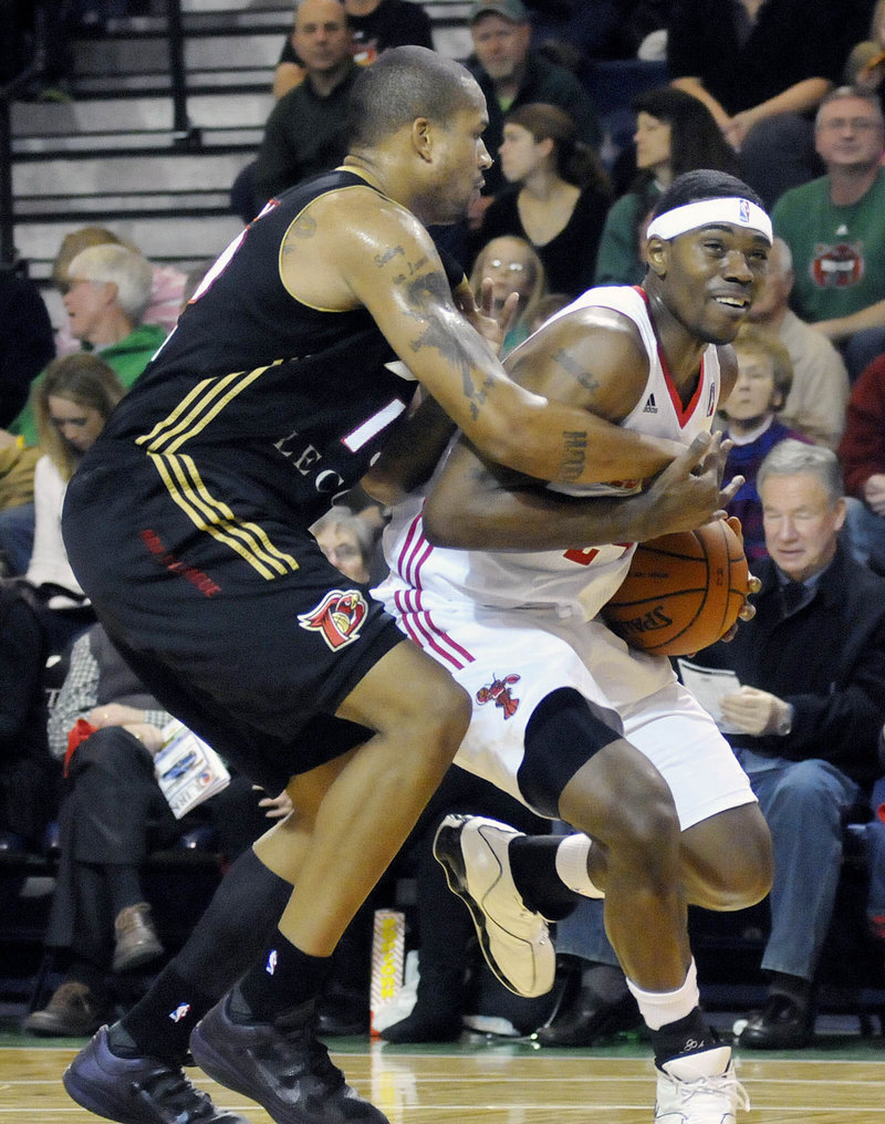 Paul Harris, right, of the Red Claws keeps possession of the ball Saturday night while fouled by Kyle Spain of the Erie BayHawks. Erie won 109-105 at the Portland Expo.