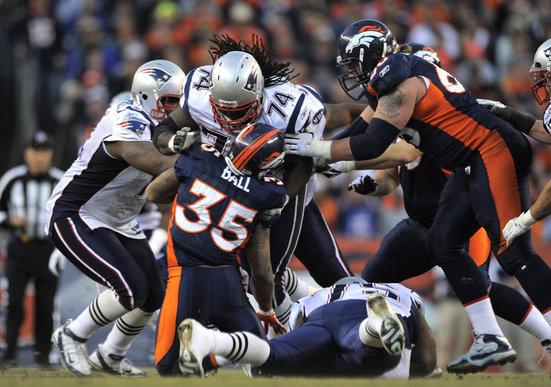 Kyle Love, 74, slams Denver Broncos running back Lance Ball in Sunday’s game at Denver. The Patriots’ defense allowed 167 rushing yards in the first quarter before regrouping in a 41-23 win over the Broncos.