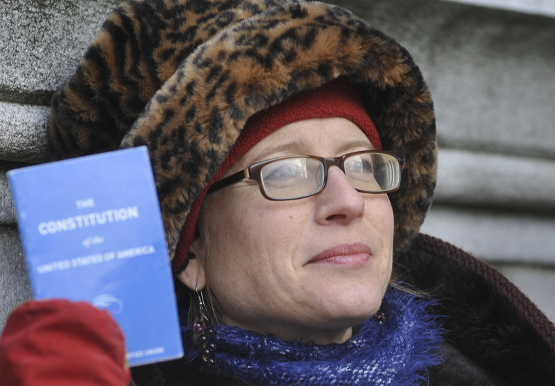 Heather Curtis, a plaintiff in the Occupy Maine lawsuit filed Monday against the city of Portland, holds a U.S. Constitution booklet outside Superior Court.