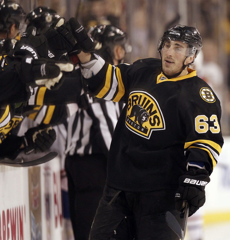 Brad Marchand gets congratulated by players on the Bruins’ bench after scoring in the third period Monday night in Boston. The Bruins won 3-2 over the Montreal Canadiens.