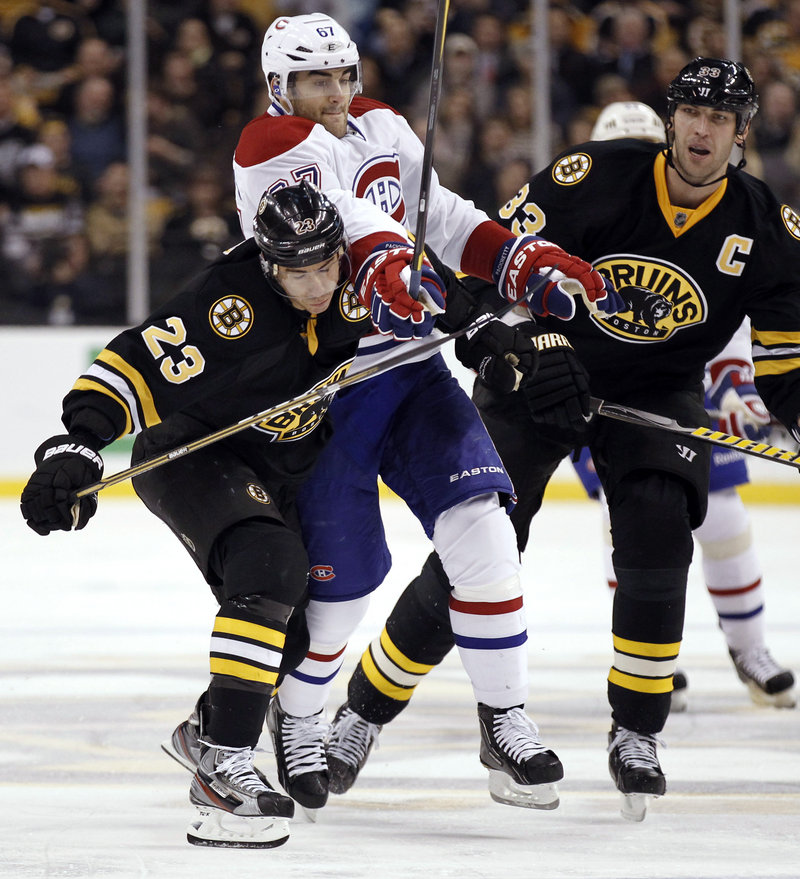 Chris Kelly of the Bruins gets help from Zdeno Chara in keeping Montreal’s Max Pacioretty away from the puck Monday night in Boston. The Bruins won 3-2, their 19th win in 22 games.