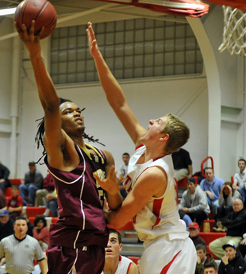 Malcolm Dopwell, of Thornton, puts back a rebound over Ben Burkey, of South Portland, Tuesday. The Trojans won the game 43-41.