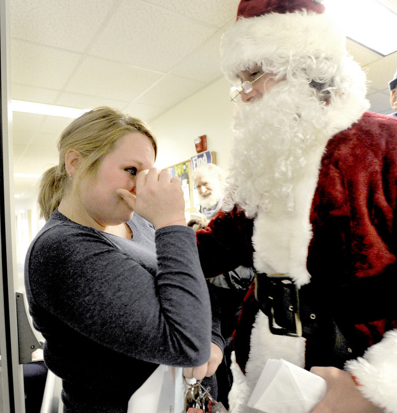 Missy Knight from Lisbon Falls wipes away a tear after receiving a $100 bill from Secret Santa’s assistant at the Mid Coast Hunger Prevention Program in Brunswick on Wednesday.