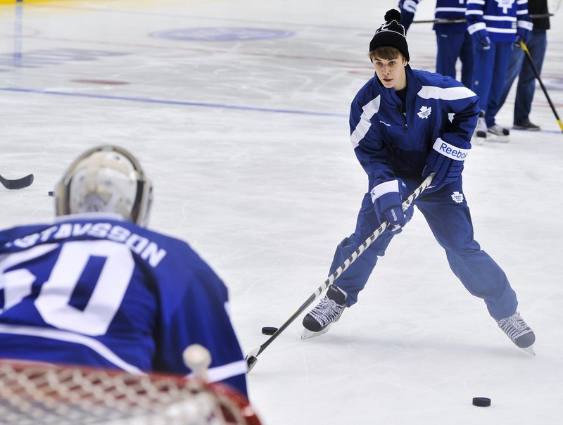 Singer Justin Bieber tries to get a shot past the Maple Leafs’ goalie Wednesday in Toronto.