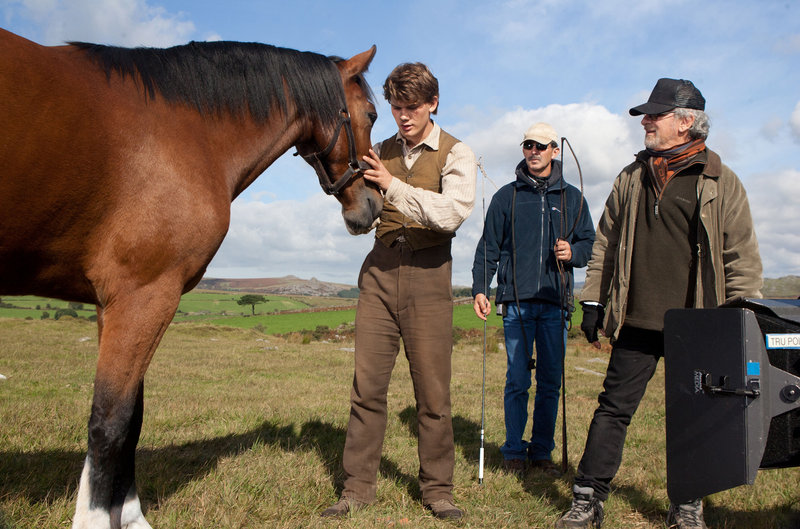 Director Steven Spielberg, far right, observes Jeremy Irvine, left, rehearse a scene with Joey on the set of “War Horse,” an epic adventure set against a sweeping canvas of rural England and Europe during the First World War.