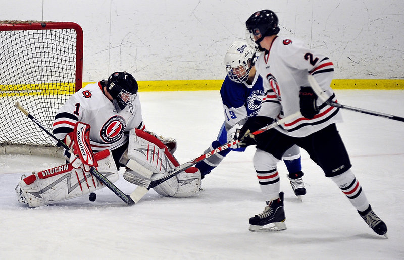 Scarborough goalie Alex Cherry looks for the puck Thursday night after making a save while Kurt Oakman of Kennebunk attempts to get a stick on it. Moving in to help for Scarborough is Ian Morris. Scarborough remained undefeated with a 3-2 victory.