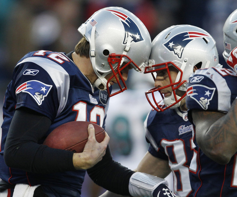 New England Patriots quarterback Tom Brady, left, celebrates his fourth-quarter touchdown that tied the game with Wes Welker – all part of a comeback from a 17-0 deficit in a 27-24 victory Saturday against the Miami Dolphins. Brady hit 27 of 46 passes for 304 yards.