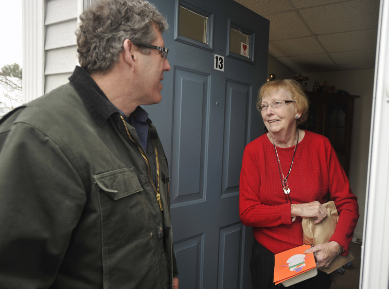 Volunteer Greg Shinberg chats with Meals on Wheels client Kathy Porier at her Westbrook home after making a meal delivery on Christmas Day.
