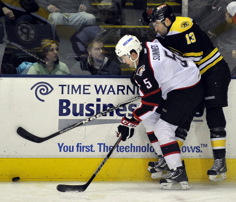 Chris Summers of the Portland Pirates attempts to keep Kirk MacDonald of the Providence Bruins away from the puck Wednesday night at the Cumberland County Civic Center.