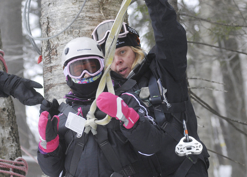 Hannah Connell, 10, of Orlando, Fla., gets hooked up to her zip line with the help of guide Patty Pittman at Sunday River in Newry on Friday.