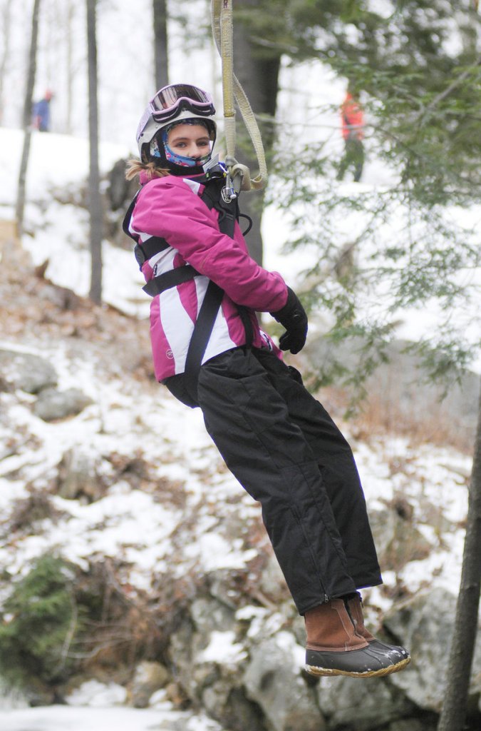 Lauren Connell, 12, of Orlando, Fla., moves down a zip line at Sunday River in Newry on Friday, while staying tightly bundled in her winter gear.