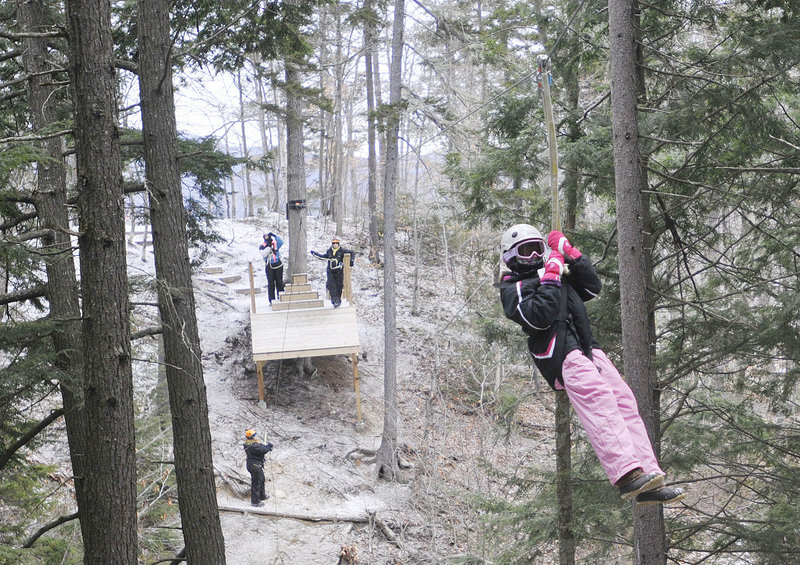 Hannah Connell, 10, of Orlando, Fla., a moves through the forest on a zip line at Sunday River in Newry on Friday.