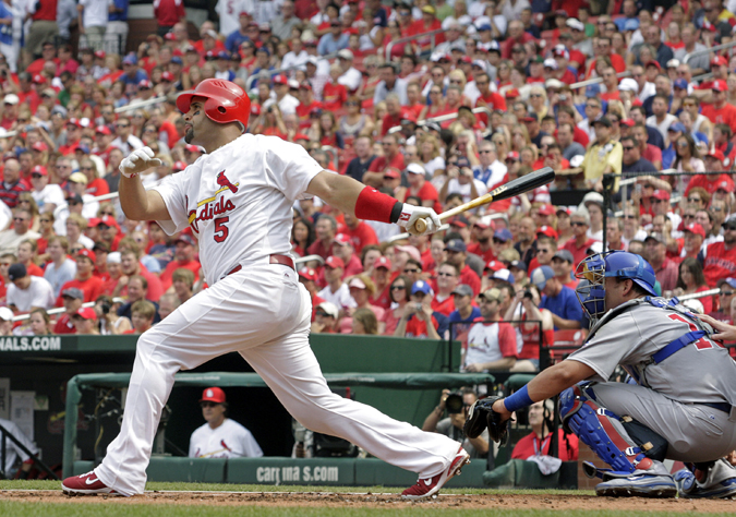 In this July 30, 2011, photo, then-St. Louis Cardinals first baseman Albert Pujols follows through on a solo home run in a game against the Chicago Cubs.