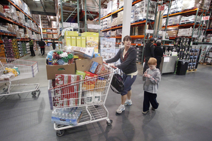 Jenni Weber and her son Jacob, 7, of Portland, Ore., shop at a Costco store recently. Costco's revenue at stores open at least a year rose 7 percent in December.