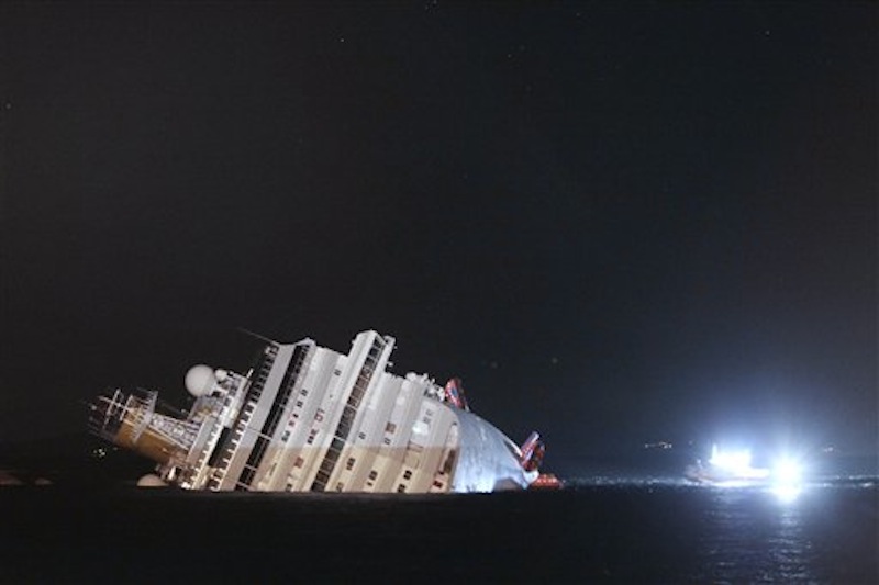 The luxury cruise ship Costa Concordia leans on its side after running aground the tiny Tuscan island of Giglio, Italy, Saturday, Jan. 14, 2012. The ship ran aground off the coast of Tuscany, sending water pouring in through a 160-foot (50-meter) gash in the hull and forcing the evacuation of some 4,200 people from the listing vessel early Saturday. (AP Photo/Gregorio Borgia)