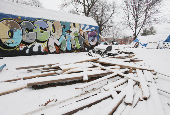 Snow covers a pile of wood at the Occupy Maine encampment in Lincoln Park in Portland. The city asked members to clean up the debris and remove unoccupied tents and structures.