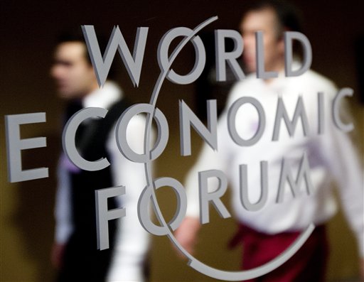 Participants pass by a mirror with the logo of the World Economic Forum in Davos, Switzerland. The overarching theme of the meeting, which takes place today through Sunday, is "The Great Transformation: Shaping New Models."
