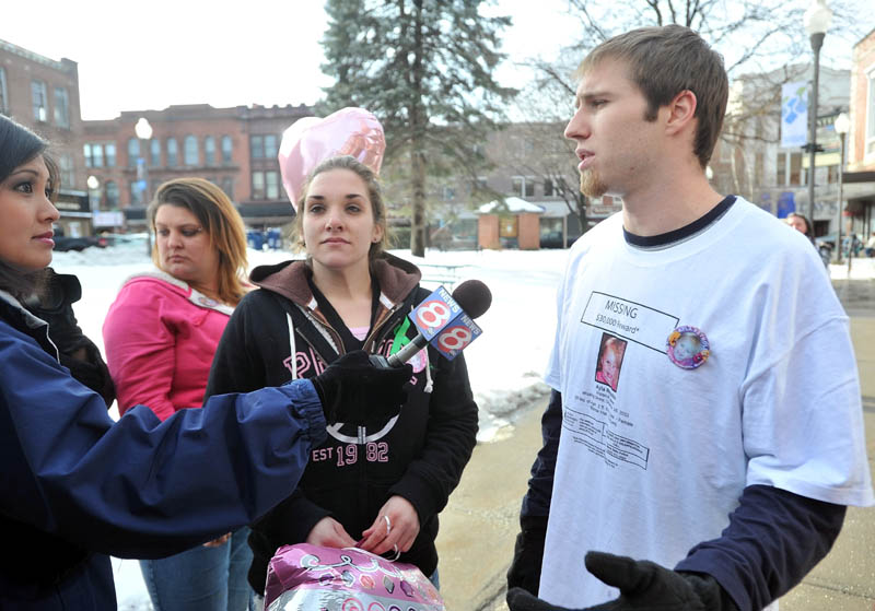 Trista Reynolds, center, and Justin DePietro, right, parents of missing toddler Ayla Reynolds, talk with media during a vigil in Castonguay Square in Waterville Saturday.