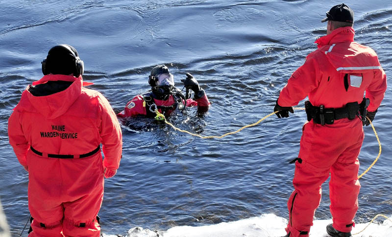 A Maine Warden Service diver comes up from the Kennebec River to speak with other wardens on the banks below the Hathaway Center in Waterville while searching for Ayla Reynolds today.