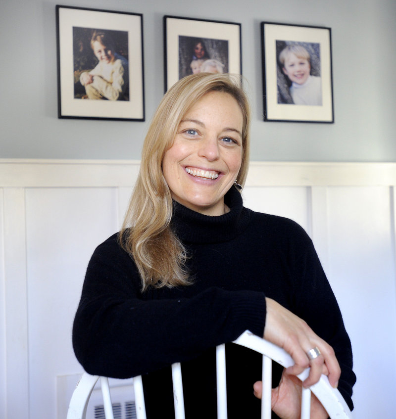 Sarah Wolf, with portraits of her children at her home in Cape Elizabeth, decided around age 40 that she’d embrace being born at the start of a new year by doing new things. She took part in a polar dip.