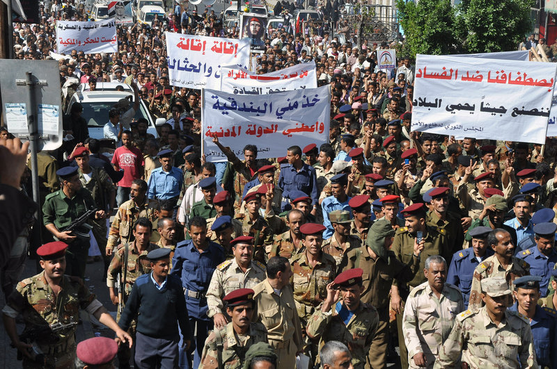 Yemeni soldiers and officers march during a rally in the southern city of Taiz on Saturday, demanding reforms and the dismissal of a senior official over allegations of corruption. The banners read, “Take from me the rifle and give me the civil state,” and “With our standing against corruption, we will build an army to protect the country.”