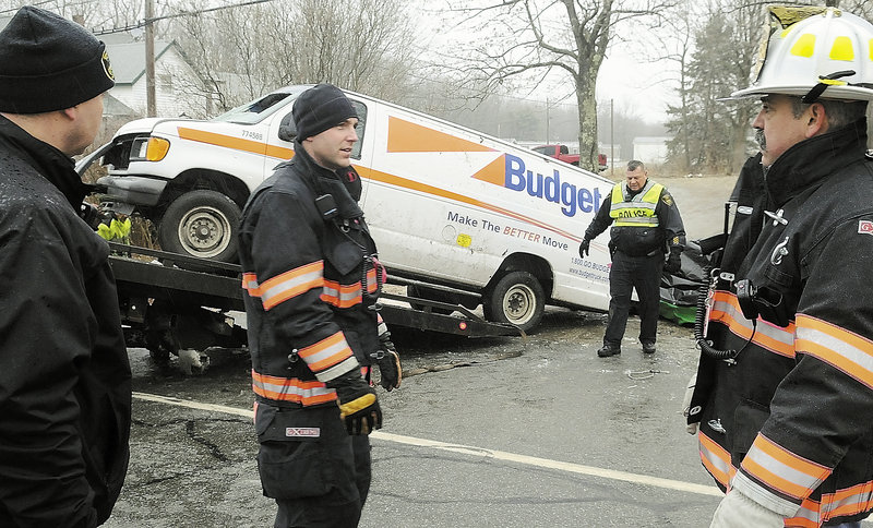 Gardiner police and firefighters remove a van that rolled over Saturday morning, claiming the lives of two men and injuring a third on Route 201 in Gardiner. Police said icy conditions contributed to the accident.