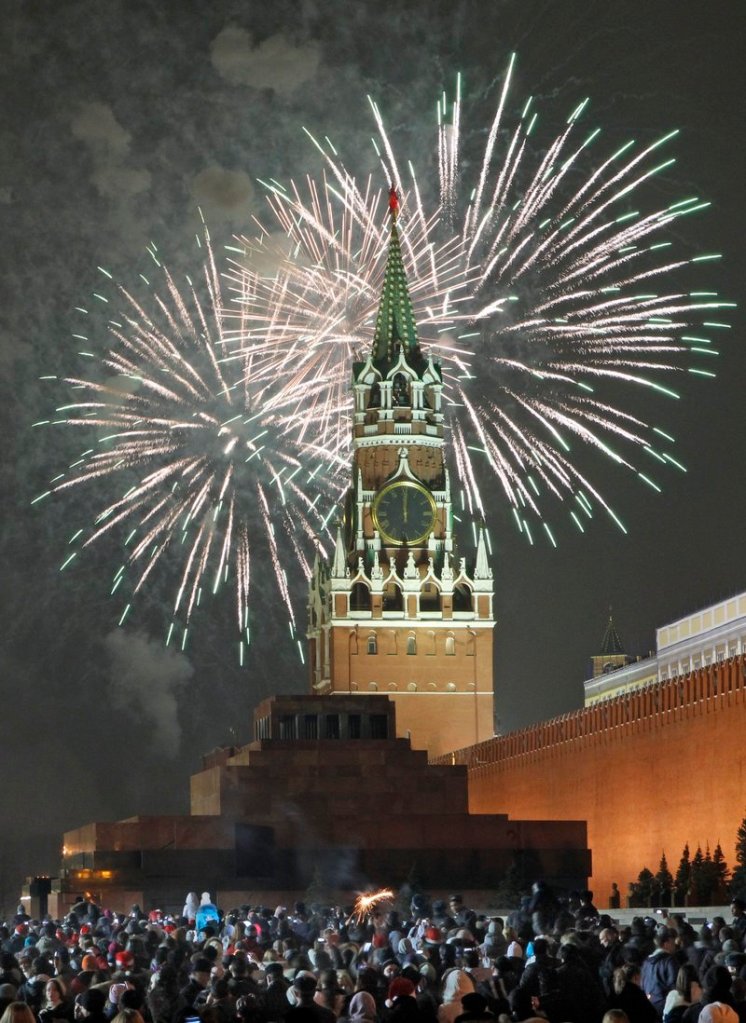 Russians celebrate the New Year on Red Square in Moscow, with the Kremlin Spassky tower and the Mausoleum of Lenin in the background, early today.