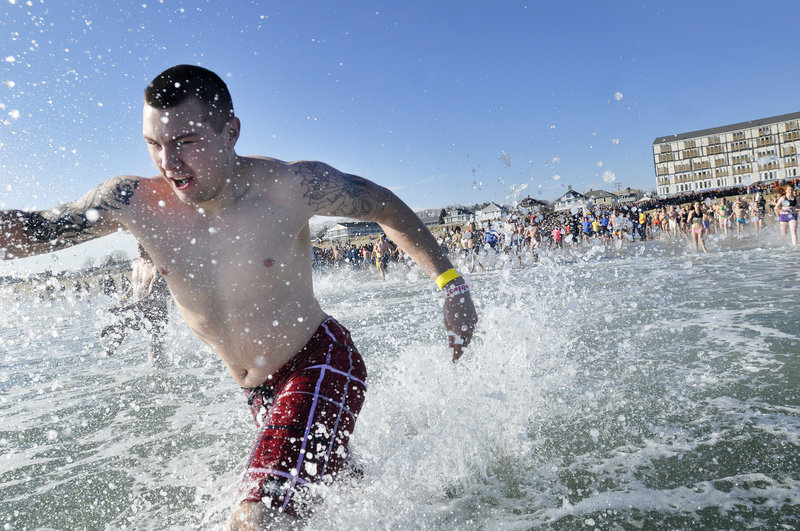 Dustin Matthews of South Portland sprints into the ocean during the event that raised $82,000 for Special Olympics Maine. The Brunswick hotel, behind him, hosted the post-dip party.