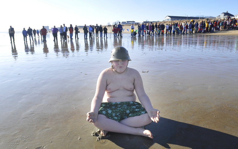 Cameron Christy, 11, of Old Orchard Beach meditates on the beach as spectators begin to line up just before the Lobster Dip on Sunday.