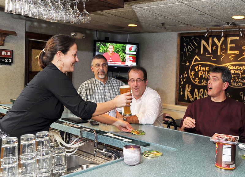 Bartender Laura Lunn serves a beer to Brian Batchelder as Mike Verville, left, and Peter Hoglund enjoy the fun and friendly service at Seasons Grille & Bar.