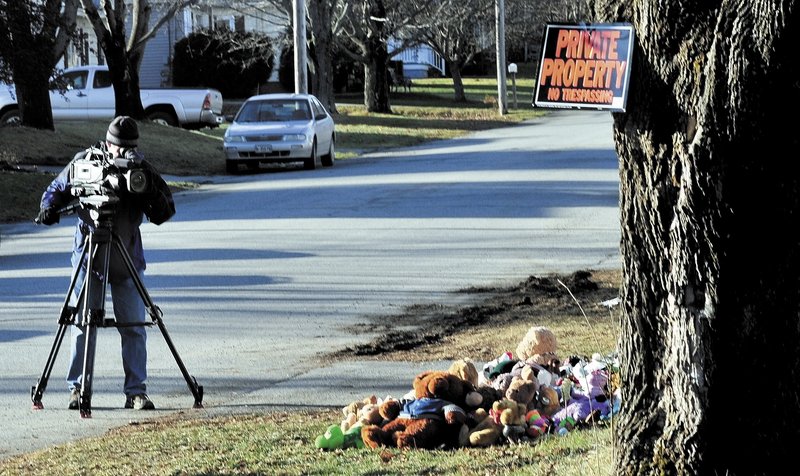 A television news photographer films a pile of stuffed animals Monday below a no-trespassing sign at the home at 29 Violette Ave. in Waterville where Ayla Reynolds was reported missing since Dec. 17. Her father, Justin DiPietro, is pleading for her safe return.