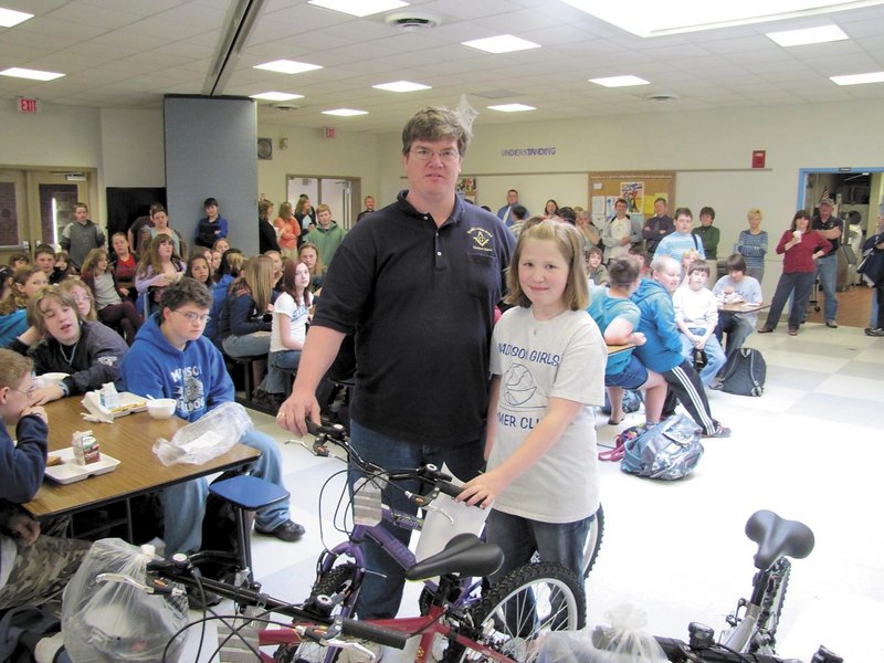 Madeline Theriault, 11, of Madison, stands with dad Mike Theriault and the bicycle she won last spring.