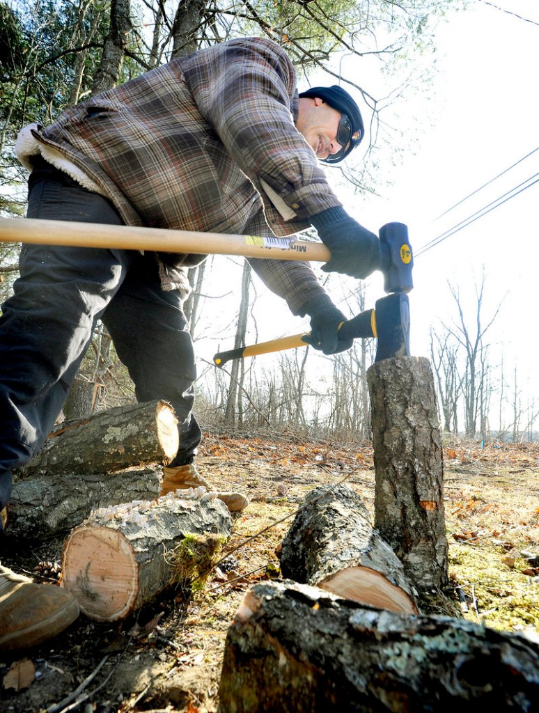 Saco resident Seamus Garrett splits logs to burn in his fireplace Wednesday during the winter’s coldest months.
