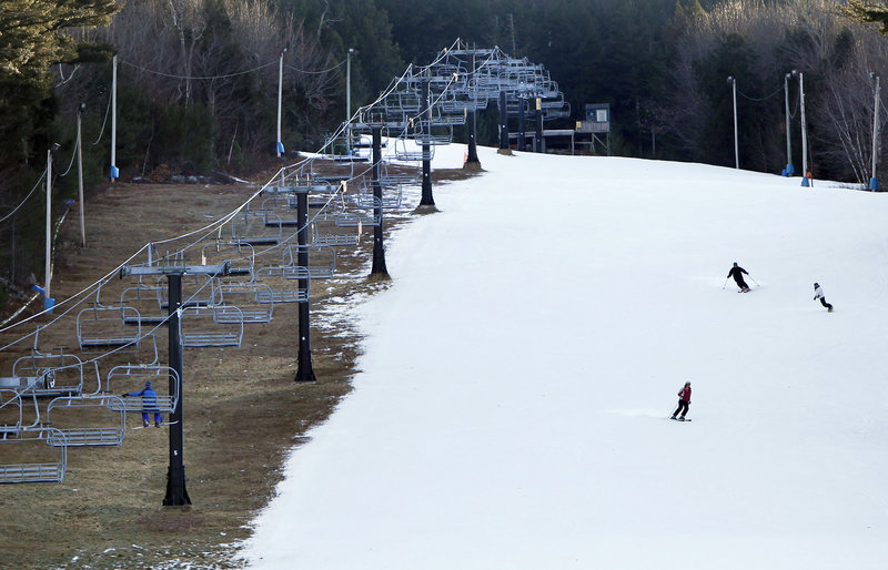 At Shawnee Peak ski area in Bridgton, man-made snow coats a ski run, but barren ground remains under the chairlift Thursday.