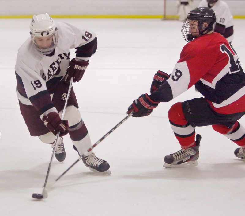 Ted Hart of Greely controls the puck Thursday night as James Zanca of Camden Hills attempts to poke it away. Greely wasn’t pleased with its game but remained unbeaten with a 4-2 victory at the Family Ice Center at Falmouth.
