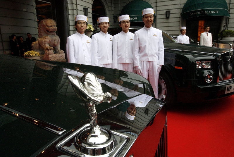 Bellboys pose after the unveiling of the new fleet of Rolls-Royce Phantoms in Hong Kong in 2006. This month, Rolls is unveiling a “Year of the Dragon” model with hand-embroidered leather headrests. Prices start at $1.6 million.
